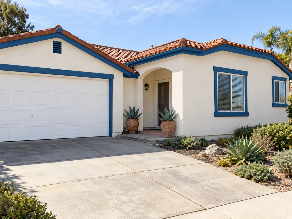 The same home with the stucco painted clean warm white, the fascia and window trim deep blue and the garage door fresh white, the same agaves by the entry